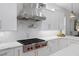 Modern kitchen with gas cooktop, stainless steel hood, and white cabinets at 3042 Wentworth Way, Tarpon Springs, FL 34688