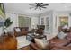Bright living room with leather sofas, coffee table, and pool view at 3042 Wentworth Way, Tarpon Springs, FL 34688