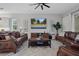 Relaxing living room featuring brown leather furniture and a ceiling fan at 3042 Wentworth Way, Tarpon Springs, FL 34688