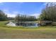 Picturesque pond with a wooden deck and tranquil reflections at 3042 Wentworth Way, Tarpon Springs, FL 34688