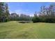 Serene pond with a wooden dock, surrounded by lush greenery at 3042 Wentworth Way, Tarpon Springs, FL 34688