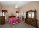 Main bedroom with ceiling fan, dresser, and access to bathroom at 306 Royal Palm Way, Spring Hill, FL 34608