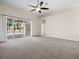 Bright living room with carpet, sliding doors to patio, and ceiling fan at 4327 Canongate Ct, Spring Hill, FL 34609