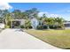 Attractive home exterior with a well-maintained lawn and palm trees at 4620 Tri Par Dr, Sarasota, FL 34234
