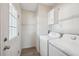 Bright laundry room with washer, dryer, and ample shelving at 4620 Tri Par Dr, Sarasota, FL 34234