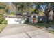 Front view of a house with a white garage door and a red front door at 4932 Wellbrook Dr, New Port Richey, FL 34653