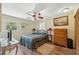 Cozy bedroom featuring a ceiling fan, dresser, and multiple windows for natural light at 7941 Sycamore Dr, New Port Richey, FL 34654