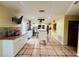 Open kitchen with island, white cabinets, and views into adjacent room at 7941 Sycamore Dr, New Port Richey, FL 34654