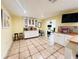 Bright kitchen with white cabinets, tiled floor, and breakfast bar at 7941 Sycamore Dr, New Port Richey, FL 34654