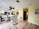 Large kitchen with island, white cabinets, and a breakfast nook at 7941 Sycamore Dr, New Port Richey, FL 34654