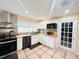 Kitchen features white cabinets, wood countertops, stainless appliances and decorative backsplash at 7941 Sycamore Dr, New Port Richey, FL 34654