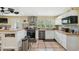 Bright kitchen features tile backsplash, updated cabinets, stainless appliances, and an island with breakfast bar at 7941 Sycamore Dr, New Port Richey, FL 34654
