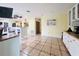 Open kitchen features white cabinets, tile floors and a large island at 7941 Sycamore Dr, New Port Richey, FL 34654