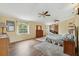 Large main bedroom features hardwood floors, multiple windows, and connecting access to a brick fireplace area at 7941 Sycamore Dr, New Port Richey, FL 34654