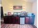 Wet bar with dark wood cabinets, granite countertop, and mini-fridge at 7941 Sycamore Dr, New Port Richey, FL 34654