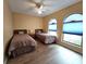 Bedroom with two twin beds, wood floors, and arched windows at 9163 Lingrove Rd, Weeki Wachee, FL 34613
