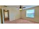 Well-lit bedroom featuring a large window and carpet flooring at 10167 Bankston Dr, Hudson, FL 34667