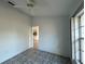 Bedroom with tiled floor, ceiling fan, large window, and a view of the dining room at 1230 Ambrose Ct, Spring Hill, FL 34608