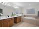 Bathroom featuring a double vanity with cabinets and soaking tub at 12499 Convent Garden Rd, Brooksville, FL 34613