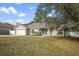 Inviting single-story home featuring a well-manicured lawn, attached garage, and lush landscaping at 12499 Convent Garden Rd, Brooksville, FL 34613