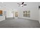 Spacious living room featuring large windows, sliding doors, and ceiling fan at 12499 Convent Garden Rd, Brooksville, FL 34613