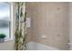 Shower/tub featuring neutral tiling, patterned shower curtain, and a window offering natural light at 12499 Convent Garden Rd, Brooksville, FL 34613