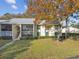 Condo building exterior with lush landscaping and fall colors at 1354 Shady Pine Way # H2, Tarpon Springs, FL 34688