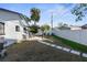 Sunny backyard with patio, landscaping, and white fence at 1718 Montana Ne Ave, St Petersburg, FL 33703