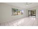 Bright living room featuring large windows, tile floors, and sliding glass doors at 2027 Beckwith Ave, Spring Hill, FL 34608