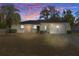 Ranch home at dusk with a palm tree and brick walkway at 2300 Restmere Ln, Spring Hill, FL 34609