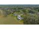 Expansive aerial view of several homes nestled in lush, green surroundings with mature trees and a sprawling lawn at 24005 Frederick Dr, Brooksville, FL 34601