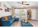 Living room with L-shaped sofa, wood-look floors, and large windows at 26416 Mcallister St, Brooksville, FL 34602