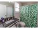 Clean bathroom with a green shower curtain and granite vanity at 3168 Sea Grape Dr, Hernando Beach, FL 34607