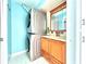 Bathroom with light blue walls, wood vanity, and stacked washer/dryer at 4375 Tahitian Gardens Cir # B, Holiday, FL 34691