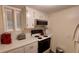 Bright kitchen features white cabinets, built-in microwave, and electric range at 4746 Azalea Dr # 209, New Port Richey, FL 34652