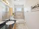 Clean bathroom with a bathtub, granite vanity, and neutral tile at 7516 Gulf Way, Hudson, FL 34667