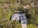 Aerial view showcasing house, pool, and surrounding trees at 92 Randolph Ave, Spring Hill, FL 34606