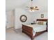 Bright bedroom with a wooden sleigh bed, mirror, and ceiling fan at 92 Randolph Ave, Spring Hill, FL 34606