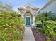 Stone and column entryway with lush landscaping and a teal front door at 92 Randolph Ave, Spring Hill, FL 34606