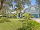 Two-story house with teal garage door and lush landscaping at 92 Randolph Ave, Spring Hill, FL 34606