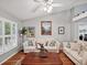 Spacious living room with hardwood floors, beige sofas, and large windows at 92 Randolph Ave, Spring Hill, FL 34606