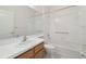 Clean bathroom with a tub, toilet, and vanity with wood cabinets at 11644 Spindrift Loop, Hudson, FL 34667