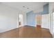 Primary bedroom with wood floors, blue accent wall, and walk-in closet at 11644 Spindrift Loop, Hudson, FL 34667