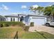 Light blue house with two-car garage and well-manicured lawn at 11644 Spindrift Loop, Hudson, FL 34667