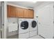 Laundry room with washer, dryer, sink, and wood cabinets at 11644 Spindrift Loop, Hudson, FL 34667