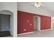 Living area with red accent wall and archways to other rooms at 11644 Spindrift Loop, Hudson, FL 34667