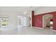 Living room with tile floors, sliding glass doors and red accent wall at 11644 Spindrift Loop, Hudson, FL 34667