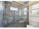 Walk-in shower with gray tile and glass enclosure at 11644 Spindrift Loop, Hudson, FL 34667