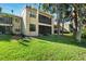 Exterior of a two-story building with a screened-in lanai and lush green lawn at 121 Lindsay Ln # 31, Oldsmar, FL 34677