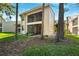 Exterior shot of a two-story residential building with a screened lanai and mature trees at 121 Lindsay Ln # 31, Oldsmar, FL 34677